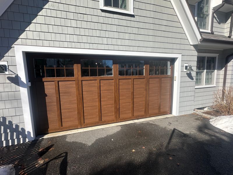 Close-up of wood craftsman garage door panels and transom window detail